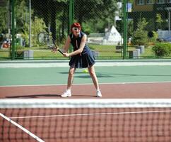 jonge vrouw speelt tennisspel buiten foto