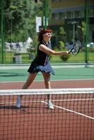 jonge vrouw speelt tennisspel buiten foto