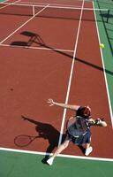 jonge vrouw speelt tennisspel buiten foto