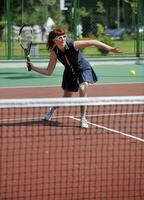 jonge vrouw speelt tennisspel buiten foto