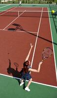 jonge vrouw speelt tennisspel buiten foto