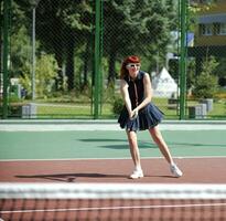 jonge vrouw speelt tennisspel buiten foto