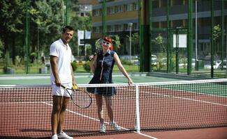 gelukkig jong paar Speel tennis spel buitenshuis foto