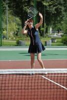 jonge vrouw speelt tennisspel buiten foto