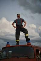 brandweerman uit van plicht Aan top van vrachtauto foto
