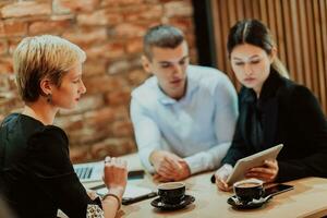 gelukkig mensen uit het bedrijfsleven glimlachen vrolijk gedurende een vergadering in een koffie winkel. groep van geslaagd bedrijf professionals werken net zo een team in een multicultureel werkplek. foto