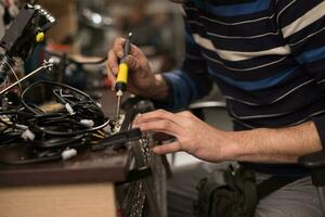 industriële werknemer man solderen kabels van productieapparatuur in een fabriek. selectieve focus foto