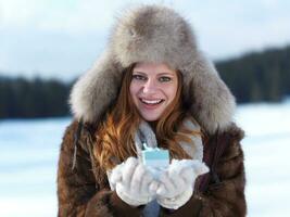 portret van meisje met geschenk Bij winter tafereel en sneeuw in backgrond foto