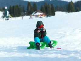 jong jongen hebben pret Aan winter vakantie en Speel spellen Aan telefoon foto