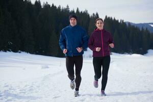 paar jogging buiten Aan sneeuw foto