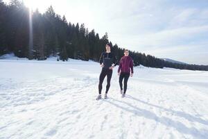 paar jogging buiten Aan sneeuw foto