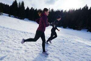 paar jogging buiten Aan sneeuw foto