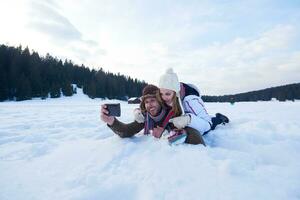 romantisch paar hebben pret in vers sneeuw en nemen selfie foto