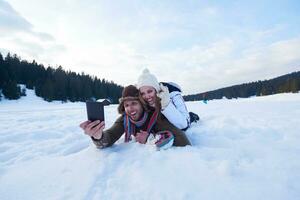 romantisch paar hebben pret in vers sneeuw en nemen selfie foto