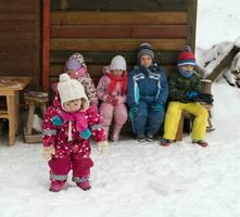 weinig kinderen groep zittend samen in voorkant van houten cabine foto