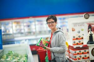 moeder met baby in boodschappen doen foto