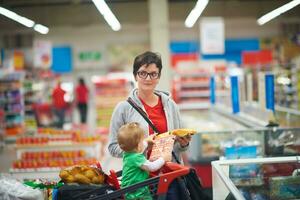 moeder met baby in boodschappen doen foto