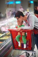 moeder met baby in boodschappen doen foto