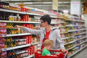 moeder met baby in boodschappen doen foto