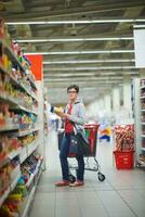 moeder met baby in boodschappen doen foto