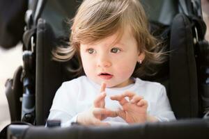 baby meisje zittend in de kinderwagen foto