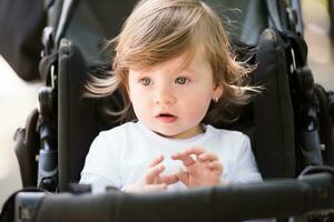 baby meisje zittend in de kinderwagen foto