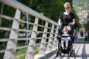 moeder geduwd haar baby dochter in een wandelwagen foto