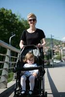 moeder geduwd haar baby dochter in een wandelwagen foto