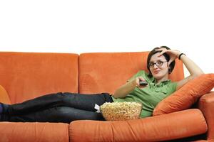 jong vrouw eten popcorn en aan het kijken TV foto