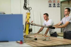 arbeiders in een fabriek van houten meubelen foto