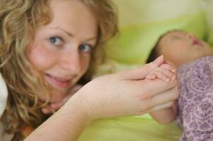 mooi jong moeder houden klein kinderen hand- foto