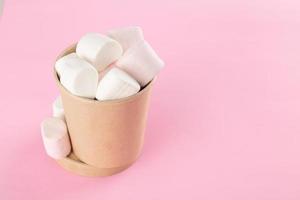 marshmallow in emmer op pastelroze achtergrond foto