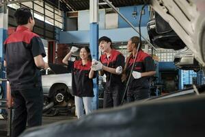 mannetje professioneel leidinggevende ingenieur en monteur arbeiders zijn vrolijk met afgewerkt reparatie werk, samenspel prestaties Bij auto onderhoud garage, en harmonisch onderhoud jobs in automotive industrie. foto