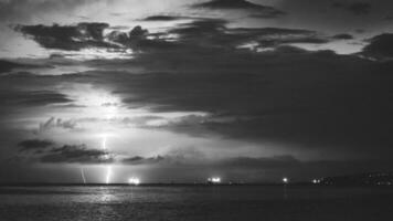episch foto van de lucht over- de zee met bliksem in de wolken. spectaculair natuur show. lang blootstelling fotografie, nacht landschap in zwart en wit