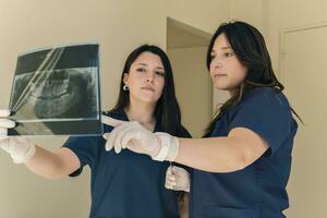 tandarts en assistent controle röntgenstraal Bij tandheelkundig kliniek foto