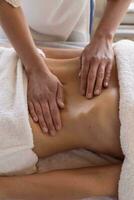 masseuse handen masseren vrouw buik in spa salon foto