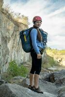 portret van vrouw klimmer op zoek Bij camera Bij voet van rotsachtig berg. foto