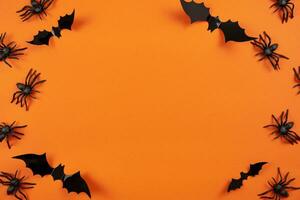 gelukkig halloween vlak leggen mockup met zwart spinnen en vleermuizen Aan oranje achtergrond. vakantie concept samenstelling. top visie. kopiëren ruimte. foto
