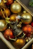 Kerstmis doos met feestelijk speelgoed en decoraties Aan donker achtergrond. retro rustiek stijl. vakantie, nieuw jaar, Kerstmis concept. vlak leggen samenstelling. top visie. foto