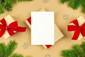 Kerstmis groet kaart mockup en verpakt geschenk dozen met rood lint en Kerstmis boom takken decoratie Aan papier achtergrond. feestelijk vlak leggen gestileerd sjabloon samenstelling. top visie. foto