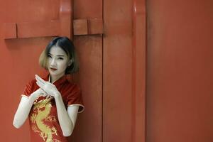 portret mooie aziatische vrouw in cheongsam-jurk, thailand-mensen, gelukkig chinees nieuwjaarsconcept, gelukkige aziatische dame in chinese klederdracht foto