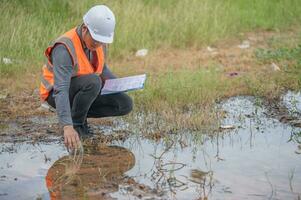 milieu-ingenieurs inspecteren de waterkwaliteit, brengen water naar het laboratorium om te testen, controleren het mineraalgehalte in water en bodem, controleren op verontreinigingen in waterbronnen. foto