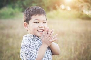 gelukkige kleine Aziatische jongen die buiten speelt. schattig Aziatisch. jongen op het veld. foto