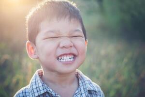 close-up van schattige Aziatische jongen die buiten speelt en lacht. foto