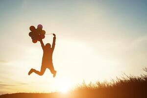 jonge vrouw met ballonnen buiten springen foto