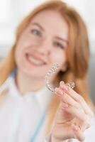 tandheelkundig zorg. glimlachen orthodontist dokter Holding tanden aligners in handen foto