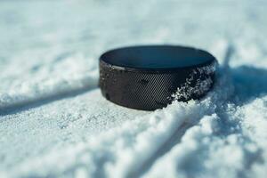 zwart hockey puck leugens Aan ijs Bij stadion foto