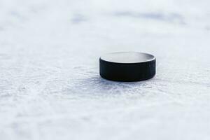 zwart hockey puck leugens Aan ijs Bij stadion foto