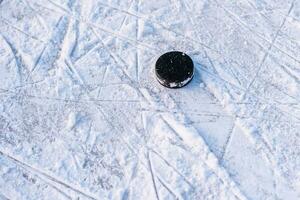 zwart hockey puck leugens Aan ijs Bij stadion foto