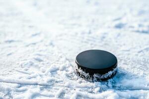 zwart hockey puck leugens Aan ijs Bij stadion foto